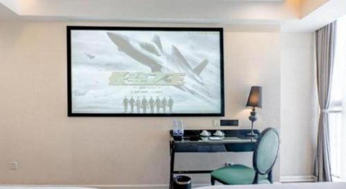 a room with a large screen on the wall with a chair at Xana Lite Anqing Yuexi Swan Squre Branch in Yuexi