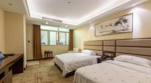 a hotel room with two beds and a desk at Li An Hotel Shantou Xiashan Central Bus Station Branch in Shantou