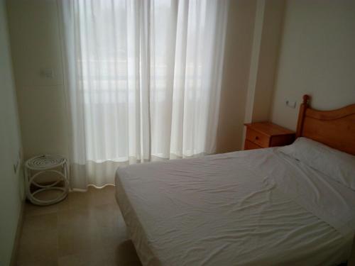 Un pat sau paturi într-o cameră la Apartamentos Gandía Universidad 3000