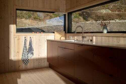a kitchen with a sink and a large window at Designer Cabin By Lake Nisser With View And Sauna in Treungen