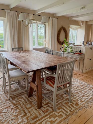 a large wooden table in a kitchen with chairs at Charming Farmhouse With Open Spaces Near Österlen in Löderup