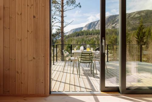 a glass door leading to a patio with a table and chairs at Designer Cabin By Lake Nisser With View And Sauna in Treungen