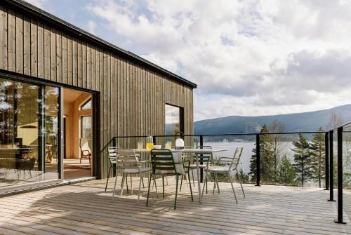 a dining room with a table and chairs on a deck at Designer Cabin By Lake Nisser With View And Sauna in Treungen