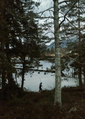 a person is standing in front of a lake at Designer Cabin By Lake Nisser With View And Sauna in Treungen
