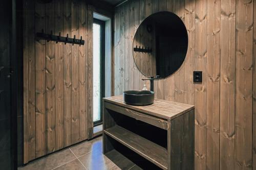 a bathroom with a sink and a mirror at Modern Mountain Cabin Near Syningtoppen in Torpo