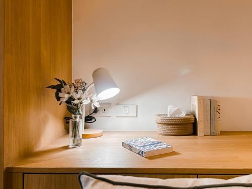 a table with a vase of flowers and a book at P.K. Garden Home in Bangkok