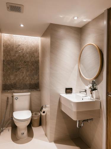 a bathroom with a toilet and a sink and a mirror at P.K. Garden Home in Bangkok