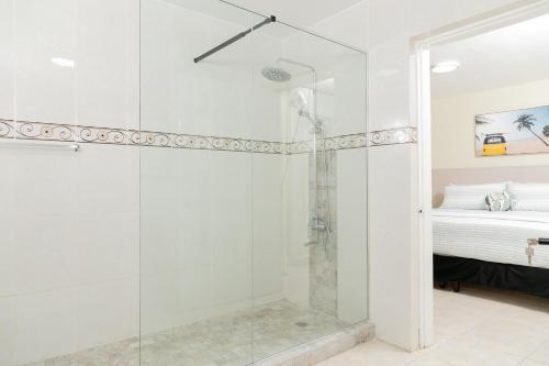 a bathroom with a glass shower with a bed at Spacious Comfort - Kingston in Kingston