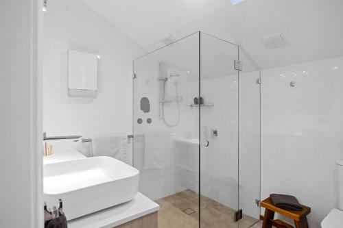 a white bathroom with a sink and a shower at Ridge Retreat in Mollymook
