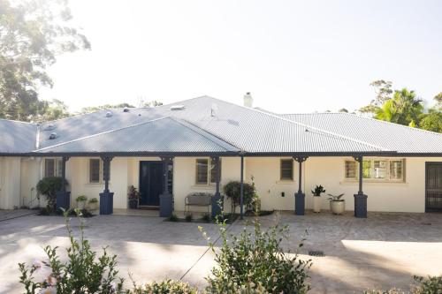 a white house with a metal roof at Ridge Retreat in Mollymook