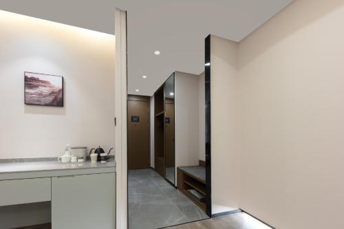 a bathroom with white walls and a mirror at Atour X Hotel West Zhongshan Road, Zhongguancun, Jiaxing in Jiaxing