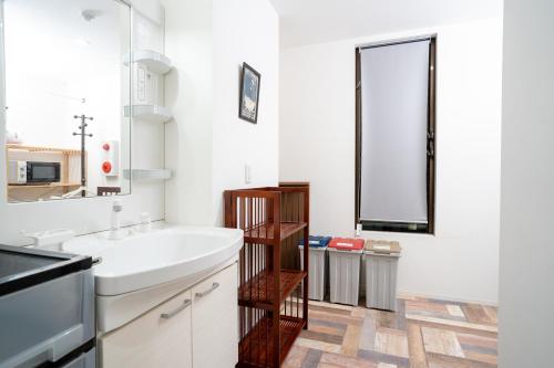 a white bathroom with a sink and a mirror at Hotel HERMIT in Takamatsu