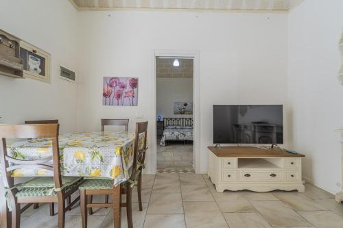 a dining room with a table and a television at La Casa del Paese in Favignana