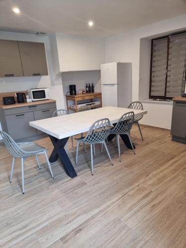 une cuisine avec une table et des chaises dans une pièce dans l'établissement Chez Remi, à Esmoulières
