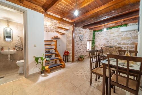 a kitchen and dining room with a stone wall at Paternal Shelter Alexander in Krousón