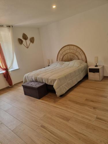 une chambre avec un grand lit et un parquet dans l'établissement Chez Remi, à Esmoulières