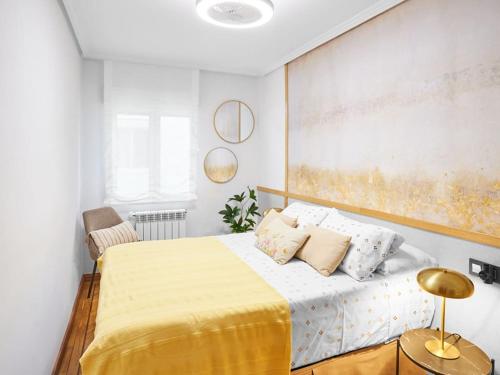 a bedroom with a large bed with a yellow blanket at Zorrilla - by Wehomes in Santander