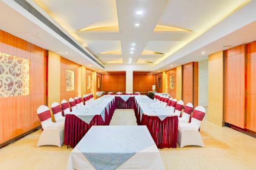 a conference room with white tables and red chairs at Palette Hotel Nisarga by Sunday Bhopal in Bhopal