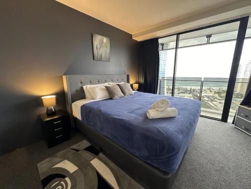 ゴールドコーストにあるSurfers Apartment Beach Mountain View Sleeps 6のベッドルーム1室(青い掛け布団、窓付)
