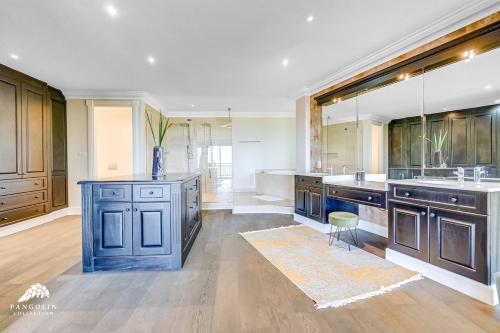 a large kitchen with wooden cabinets and a blue island at Phezulu Villas 2, Zimbali Estate by Euphoric Leisure in Ballito