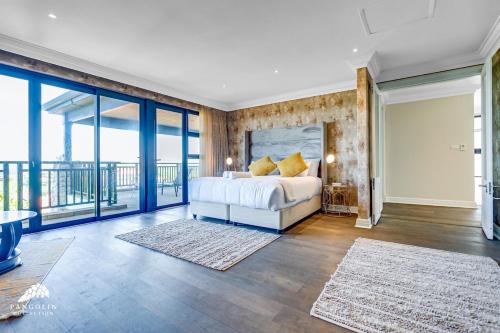 a bedroom with a bed and a balcony at Phezulu Villas 2, Zimbali Estate by Euphoric Leisure in Ballito