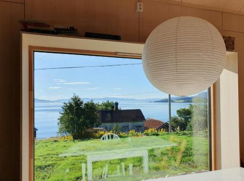 a large window with a table and a large chandelier at Architect-Designed Cabin With Beach Nearby in Lensvik