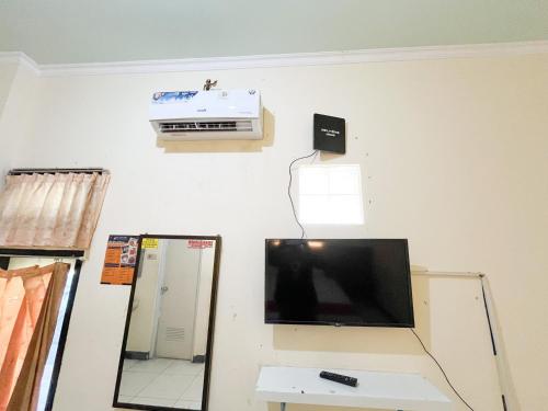 Una televisión o centro de entretenimiento en RedDoorz at Hotel Mutiara Ponorogo