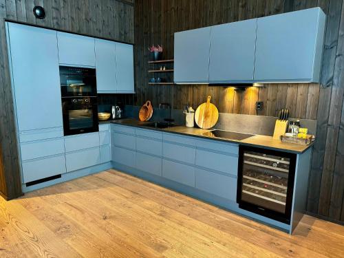 a kitchen with white cabinets and an oven at Modern Apartment Overlooking Gudbrandsdalen in Øyer