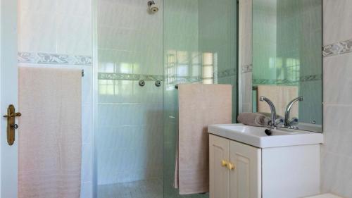 a bathroom with a shower and a sink and a mirror at Fairways 5, Zimbali Estate by Euphoric Leisure in Ballito