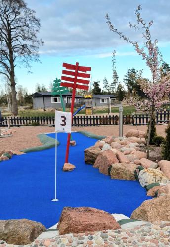 a golf course with a red flag on a blue course at Eckerö Camping & Stugor in Eckerö