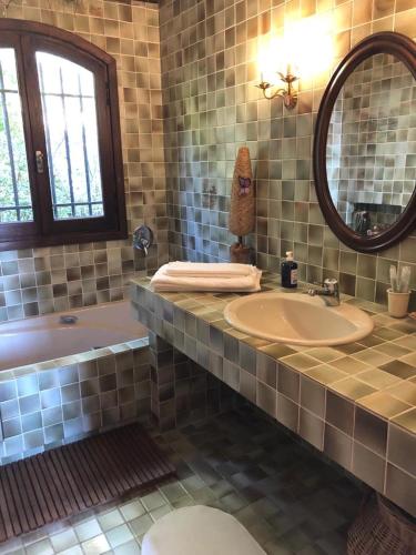 une salle de bain avec une baignoire, un lavabo et un miroir dans l'établissement Villa loucisa Nice piscine vue mer 8 chambres 24 couchages, à Nice