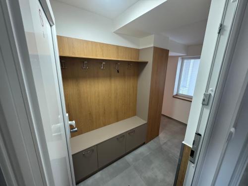 a dressing room with wooden cabinets and a window at Apartmán za Humny in Znojmo