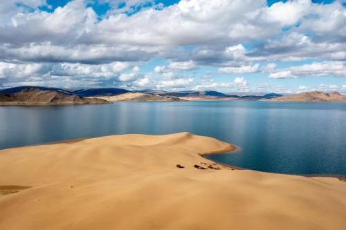 un lago nel deserto con una duna di sabbia vicino all'acqua di Tosontsengel Glamping Tents 