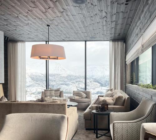 a living room with couches and a large window at Unique Cabin With Spa And Ski In-Ski Out in Hemsedal