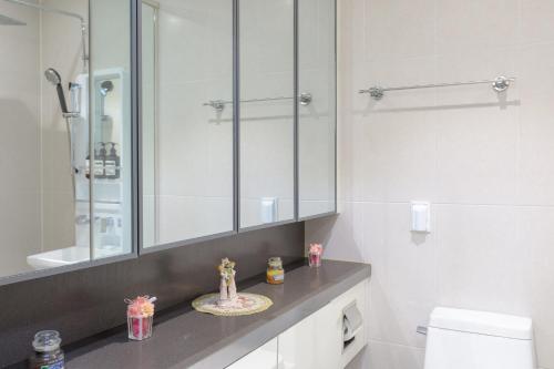 a bathroom with a sink and a mirror and a toilet at 스칼렛 스테이 수원역 - Scarlett Stay at Suwon Station in Suwon