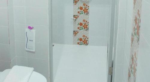 a white bathroom with a toilet and a shower at Nan Treasure Hotel in Nan