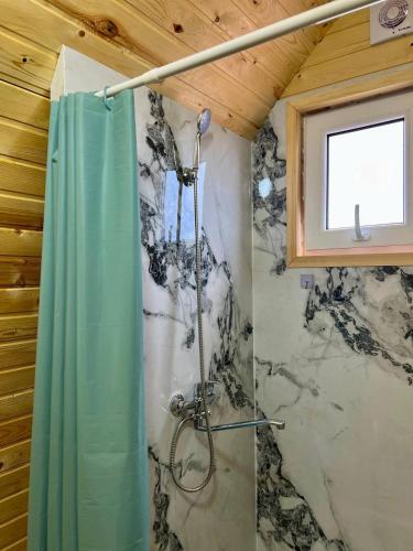 a bathroom with a shower with a shower curtain at Tasmal Yurt Camp in Tong