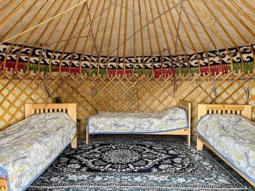 a room with two beds in a yurt at Tasmal Yurt Camp in Tong