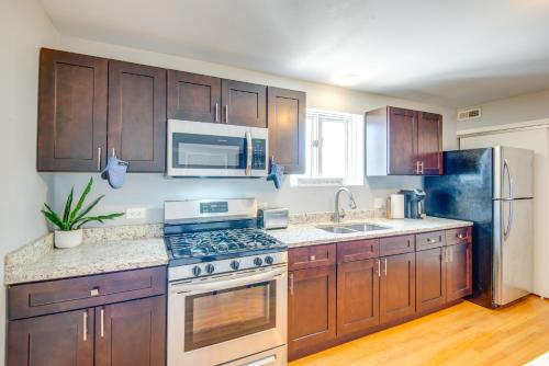 a kitchen with wooden cabinets and a stove top oven at Walk to Train and Bus Updated Chicago Apartment in Chicago