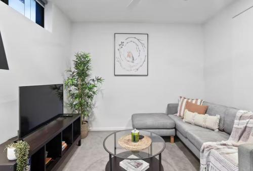 a living room with a couch and a tv at The Perfect Location Gym, Pool & Parking M22 in Brisbane