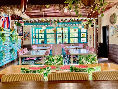a restaurant with tables and chairs in a room at Ma-Blue Garden House in Motobu