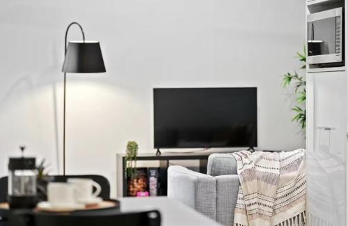 a living room with a couch and a television at The Perfect Location Gym, Pool & Parking M22 in Brisbane