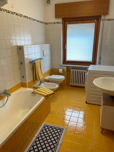 a bathroom with two toilets and a tub and a sink at Casa di Adriana in Nebbiu