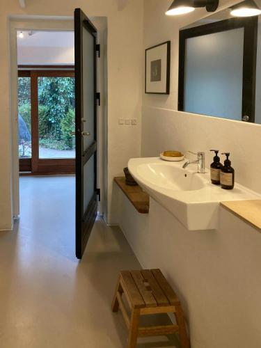 a bathroom with a sink and a mirror and a stool at Beach House With Sauna By Norsminde Harbour in Malling