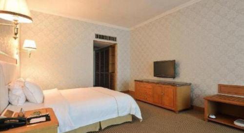 a hotel room with a bed and a television at New Pearl River Hotel in Guangzhou