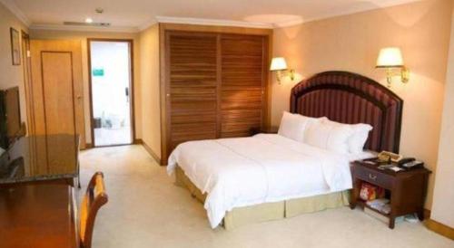 a bedroom with a large white bed and a table at New Pearl River Hotel in Guangzhou