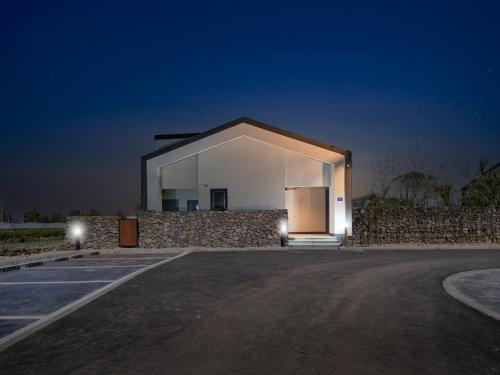 a large white building with a stone wall at Gobajinin Private Pool Villa in Jeju