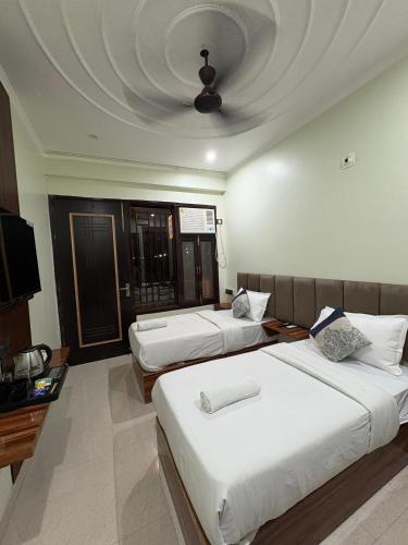 a hotel room with two beds and a ceiling at Radiant Blu Hotels in Noida