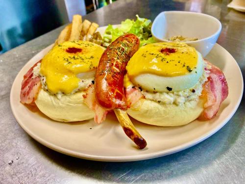 a plate with eggs and a sausage and french fries at Ma-Blue Garden House in Motobu