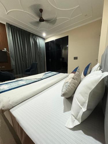 a pair of beds in a bedroom with a ceiling at Radiant Blu Hotels in Noida